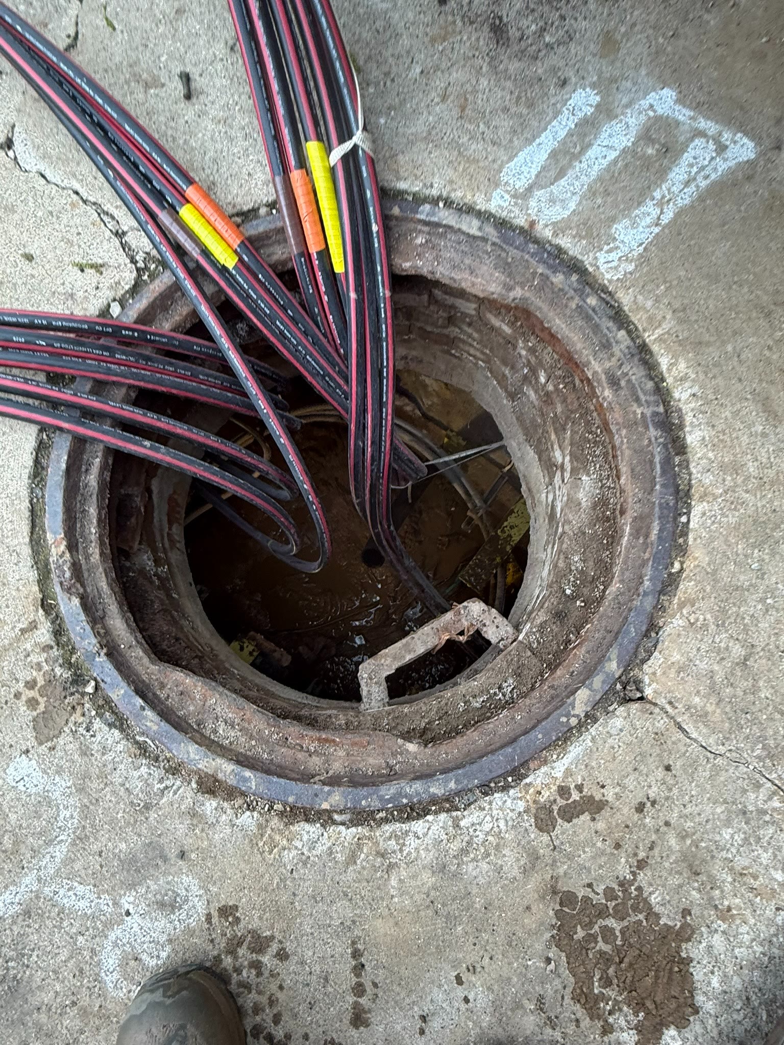 Completed underground utility handhole with organized conduit and communications lines