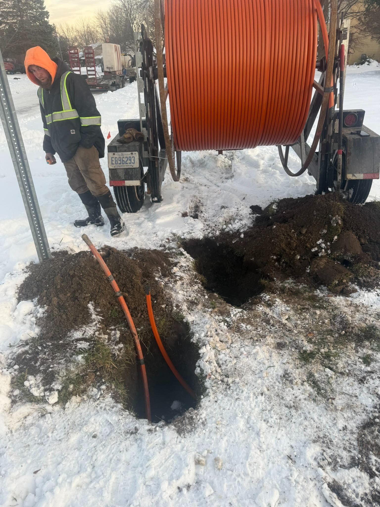 New Cable Service crew installing orange conduit in winter conditions